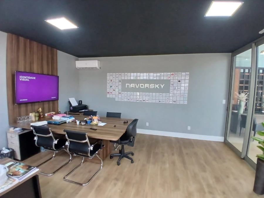 Visão ampla do escritório da Navorsky com mesa de reunião, área de trabalho e mural vibrante com referências a arte e marcas icônicas da inovação digital.